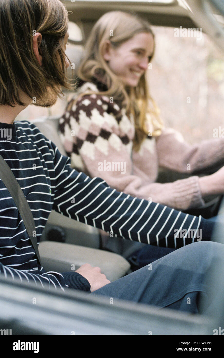 Smiling young couple driving in their car Stock Photo - Alamy