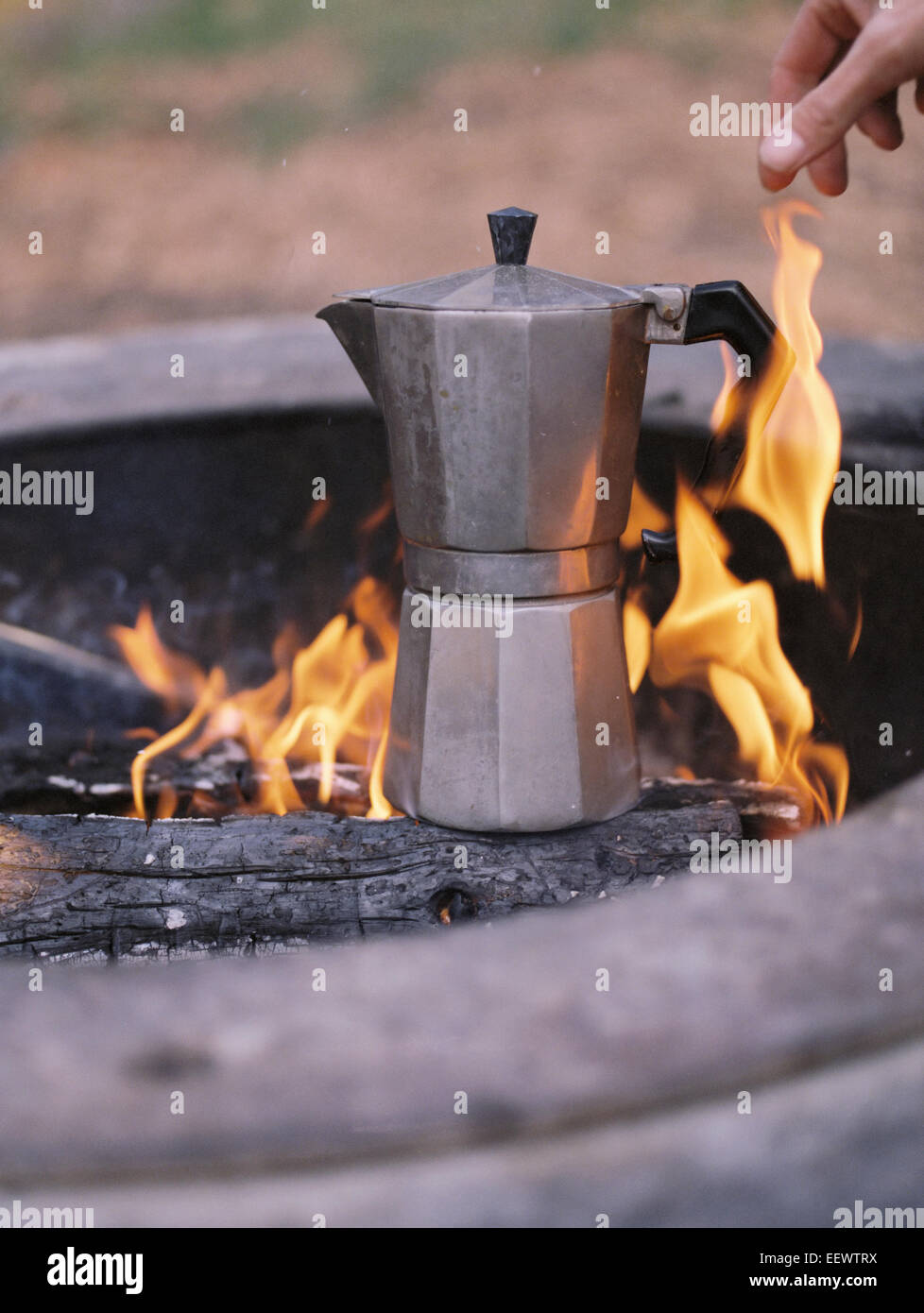 Espresso maker standing over an outdoor fire. Stock Photo
