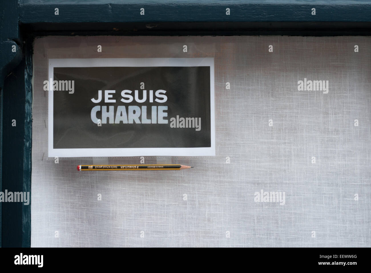 Je Suis Charlie poster and a pencil in a house window symbolizing solidarity and freedom of expression. Stock Photo