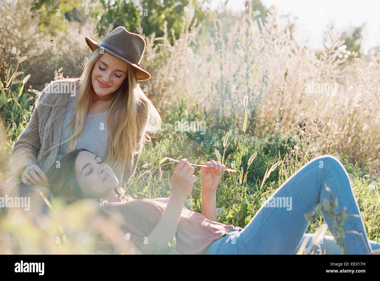 Apple orchard. Two women lying in the grass. Stock Photo