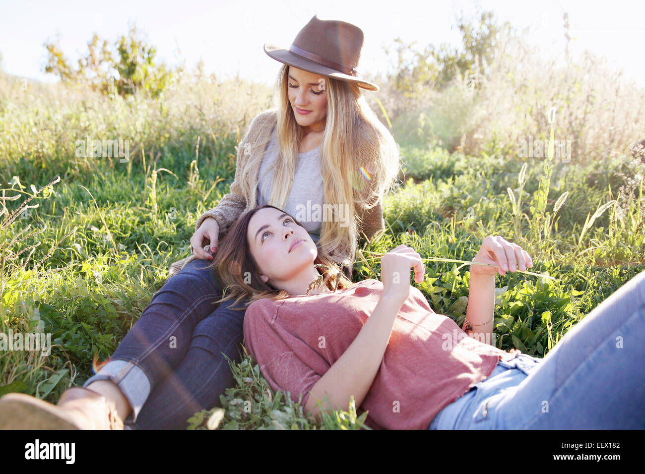 Apple orchard. Two women lying in the grass. Stock Photo