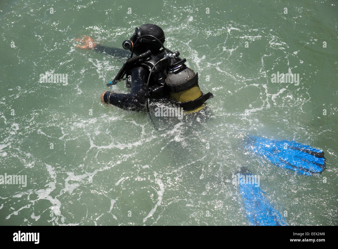 Commercial deep sea diver entering the water with a splash Stock Photo