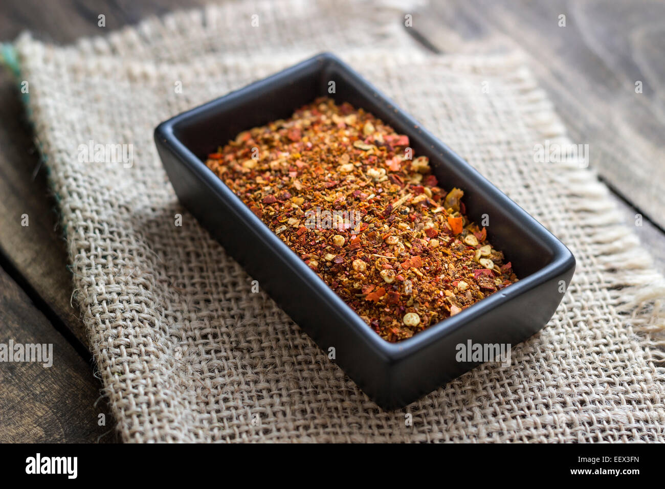 ground cayenne pepper in bowl on wooden surface Stock Photo