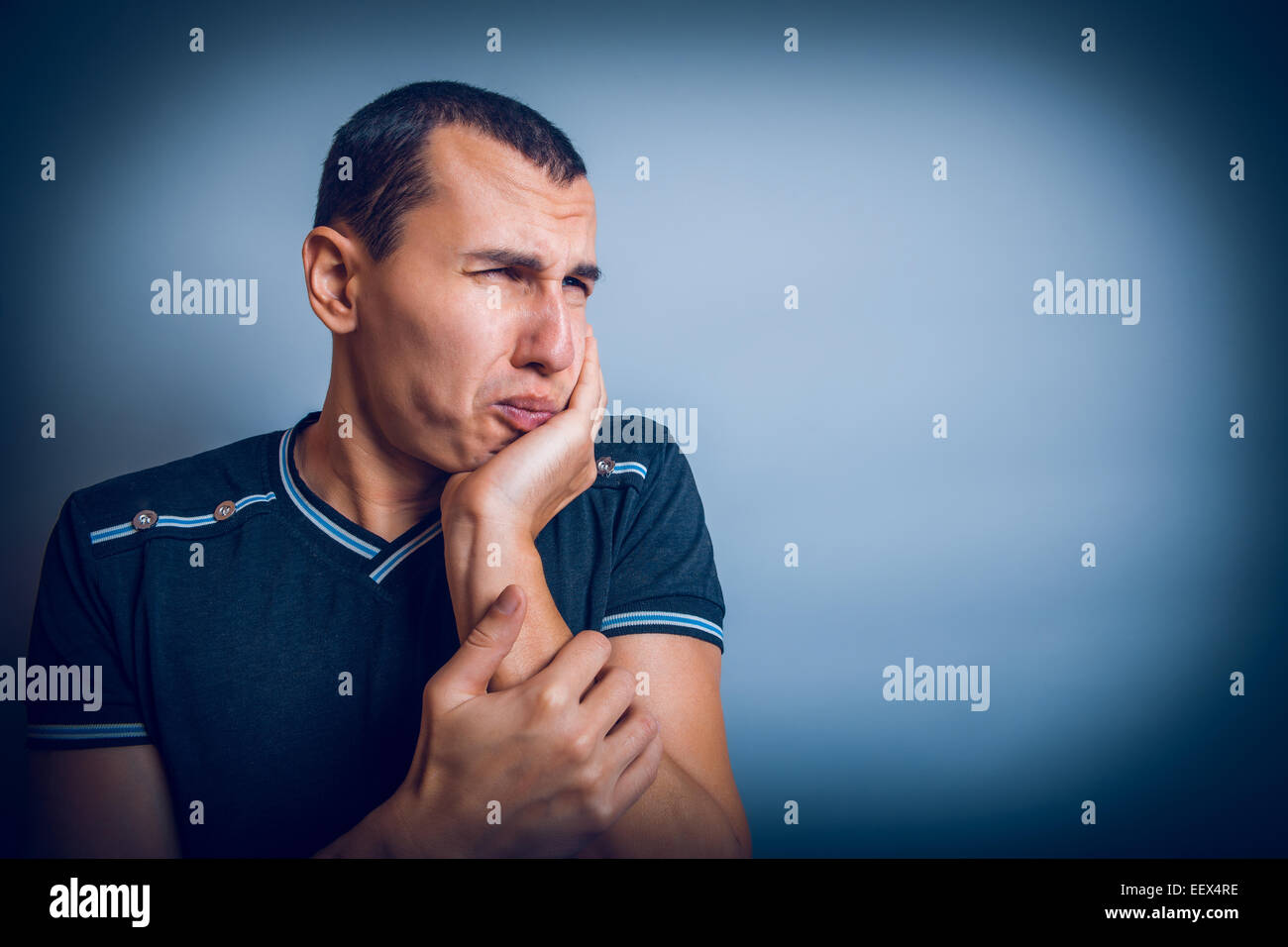 brunet the man of European appearance with his hand on  cheek Stock Photo