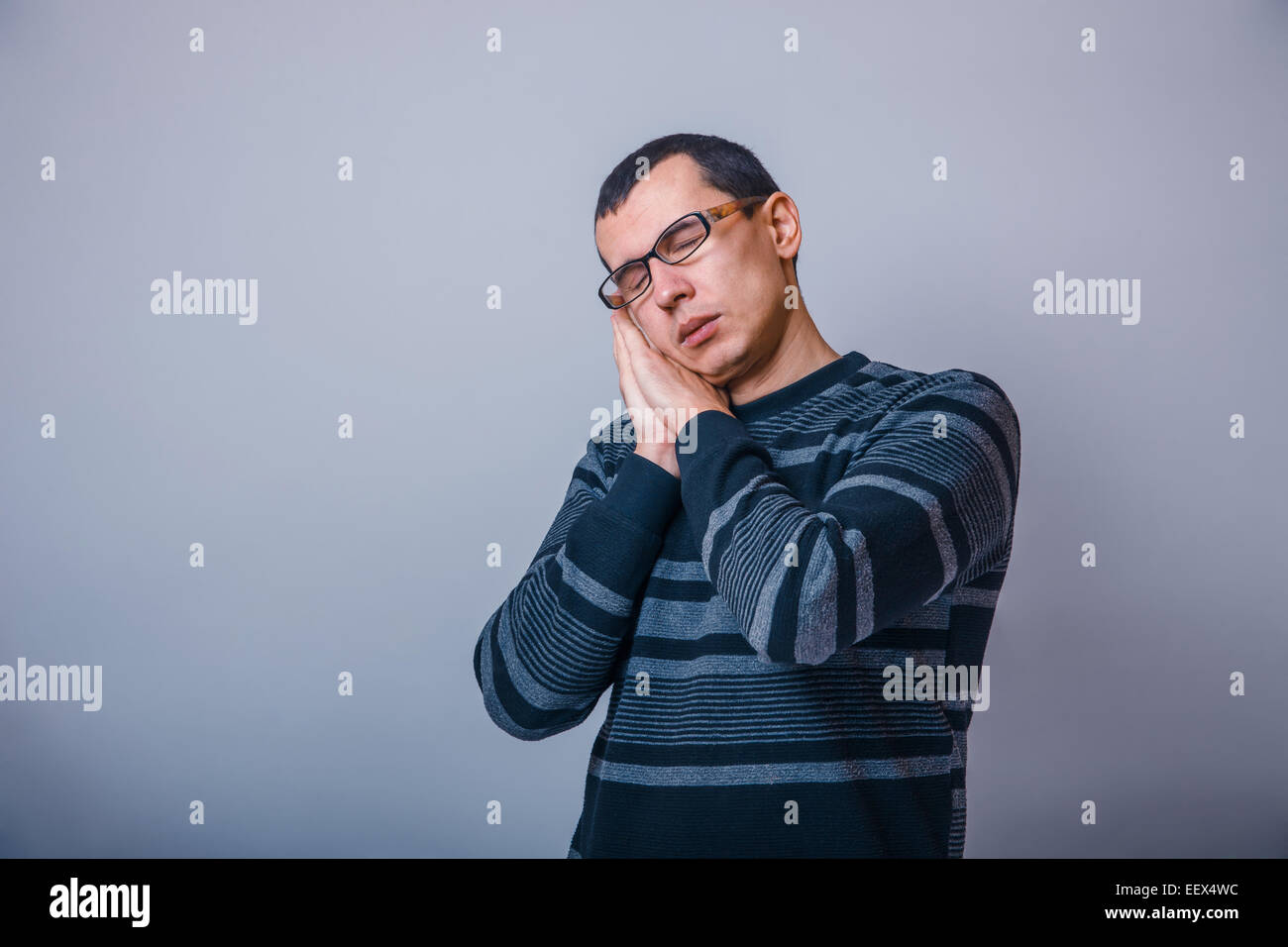 European-looking man years in glasses wants to sleep Stock Photo