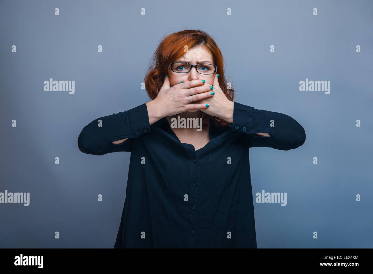 European-looking woman years his hands over mouth Stock Photo