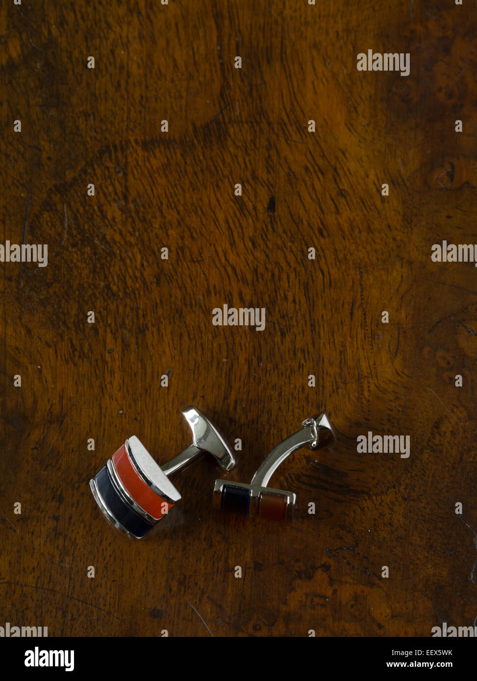 silver cufflinks on polished walnut table Stock Photo