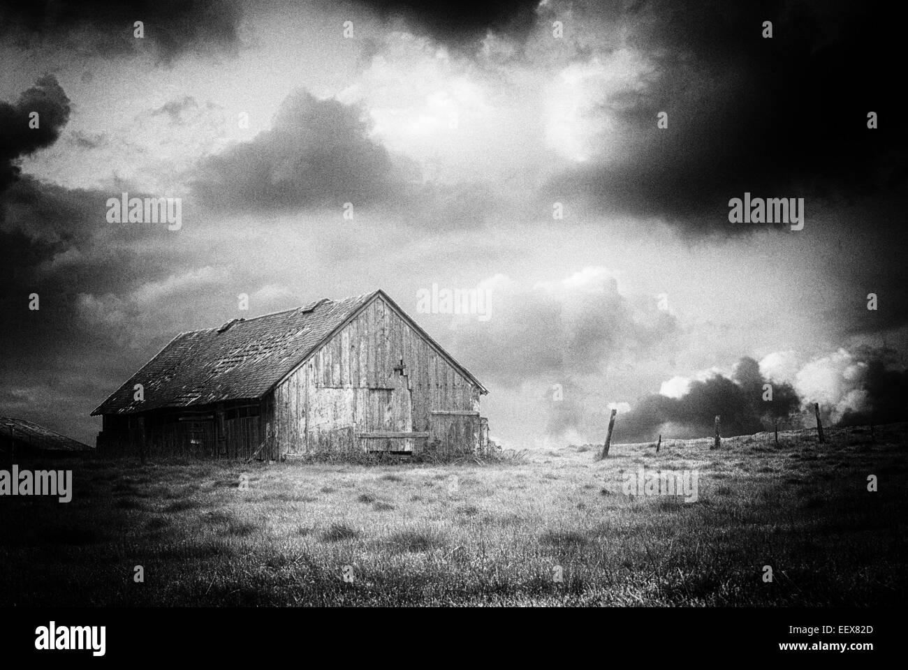 Black and White image of an old abandoned barn on a stormy nights like you would find on Halloween Stock Photo
