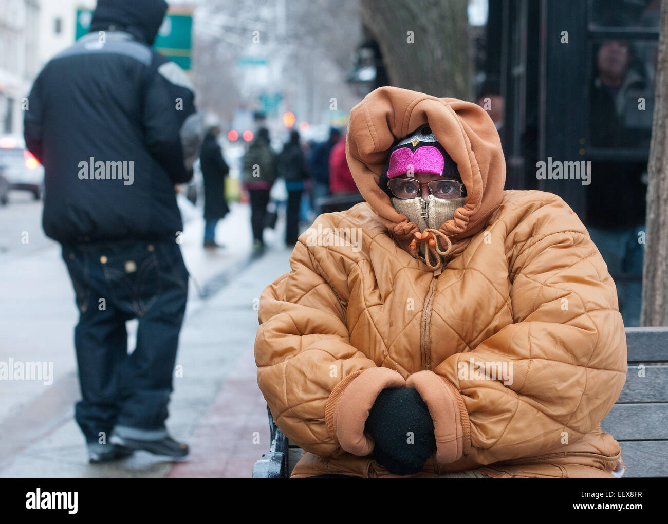 CT USA Tracey Copper of New Haven tries to keep warm as she waits for a bus after work early Thursday afternoon along Chapel Street. Copper was planning on getting home before the snowstorm began Thursday evening. pcasolino@NewHavenRegister Stock Photo
