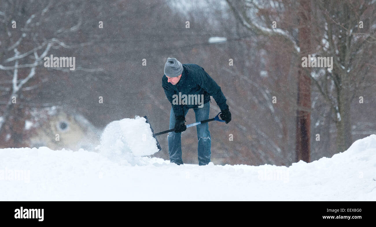 People dig out early Friday morning January 3, 2014. Chadi Noujaim shovels in front of his home along Maplewood Drive early Friday Stock Photo