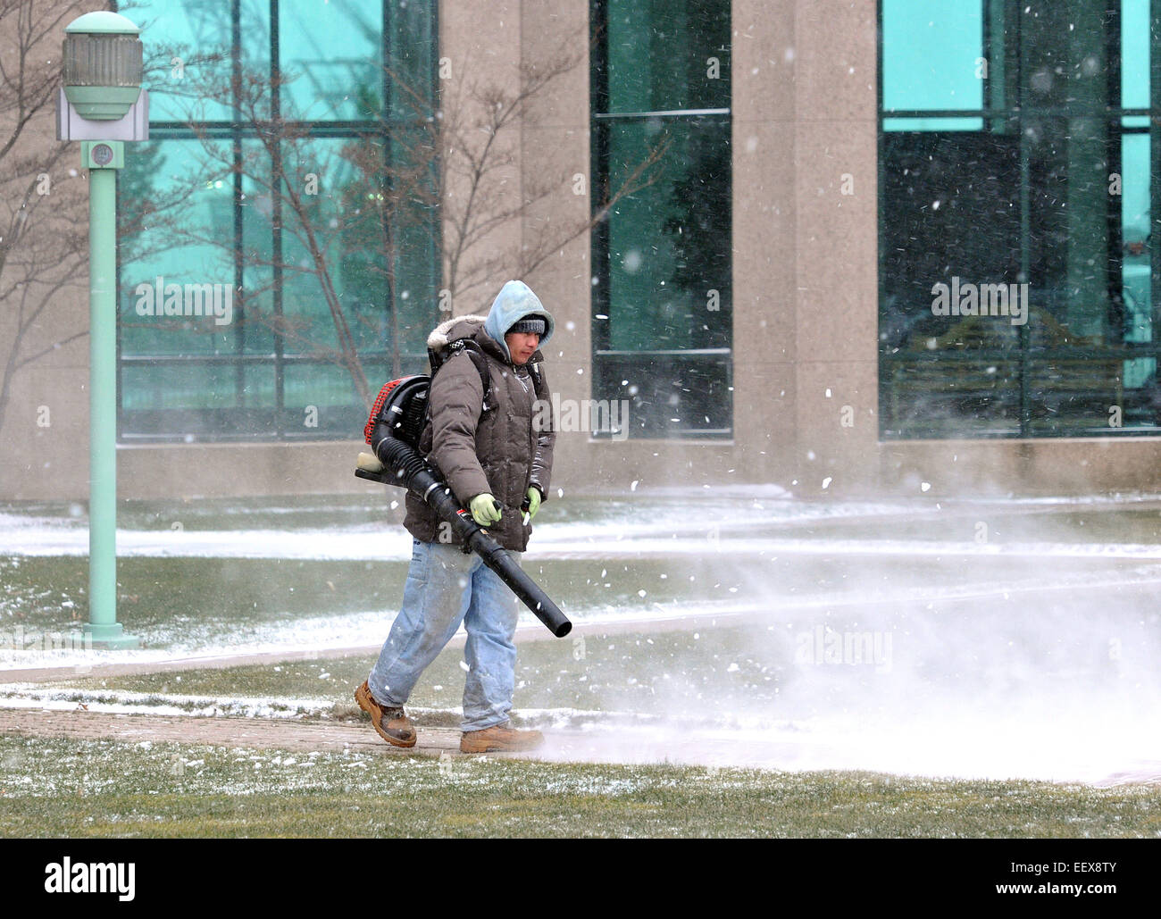 A worker clears snow with a leaf blower at the Long Wharf Maritime Center in New Haven. Stock Photo