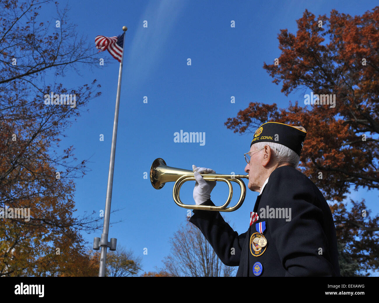 WWll Navy veteran, Daniel R. Waleski, 89, 'plays' taps during the annual Veteran's Day observance ceremony on the Derby Green, CT USA. Stock Photo