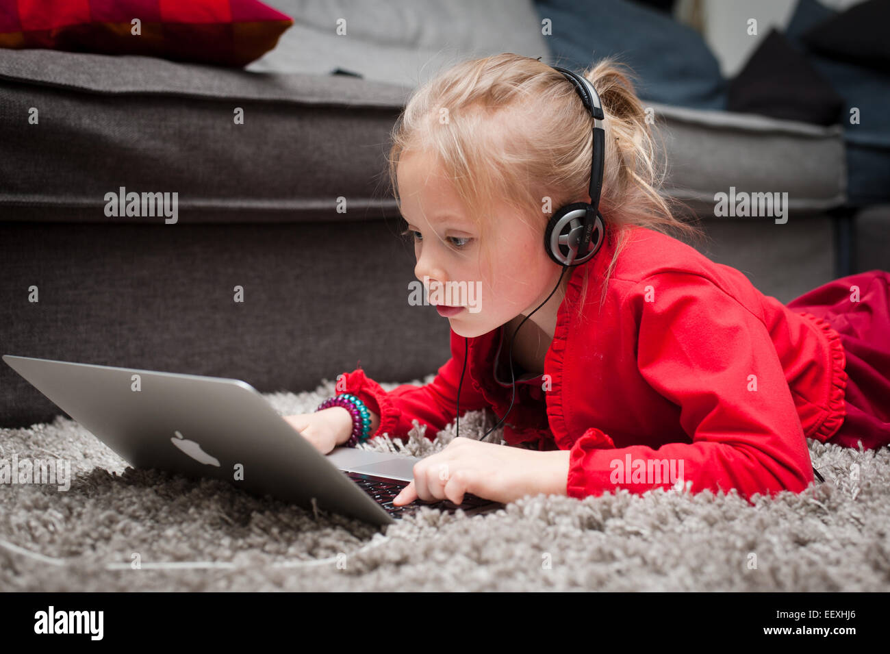 Child with headphones and laptop Stock Photo
