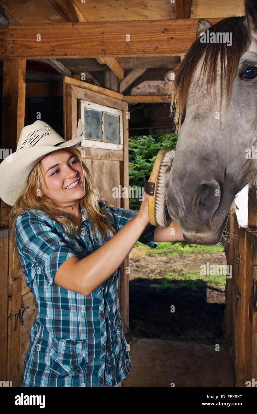 Woman in a stable with a horse Stock Photo - Alamy