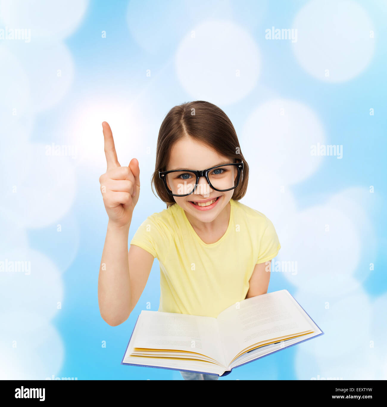 smiling little girl in eyeglasses with book Stock Photo - Alamy