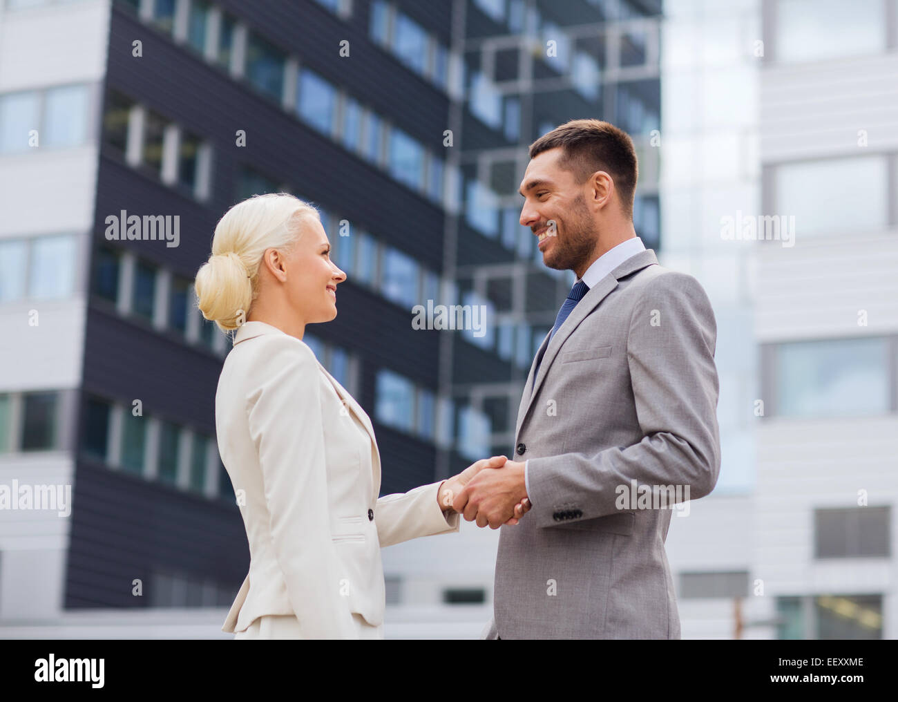 smiling businessmen standing over office building Stock Photo - Alamy