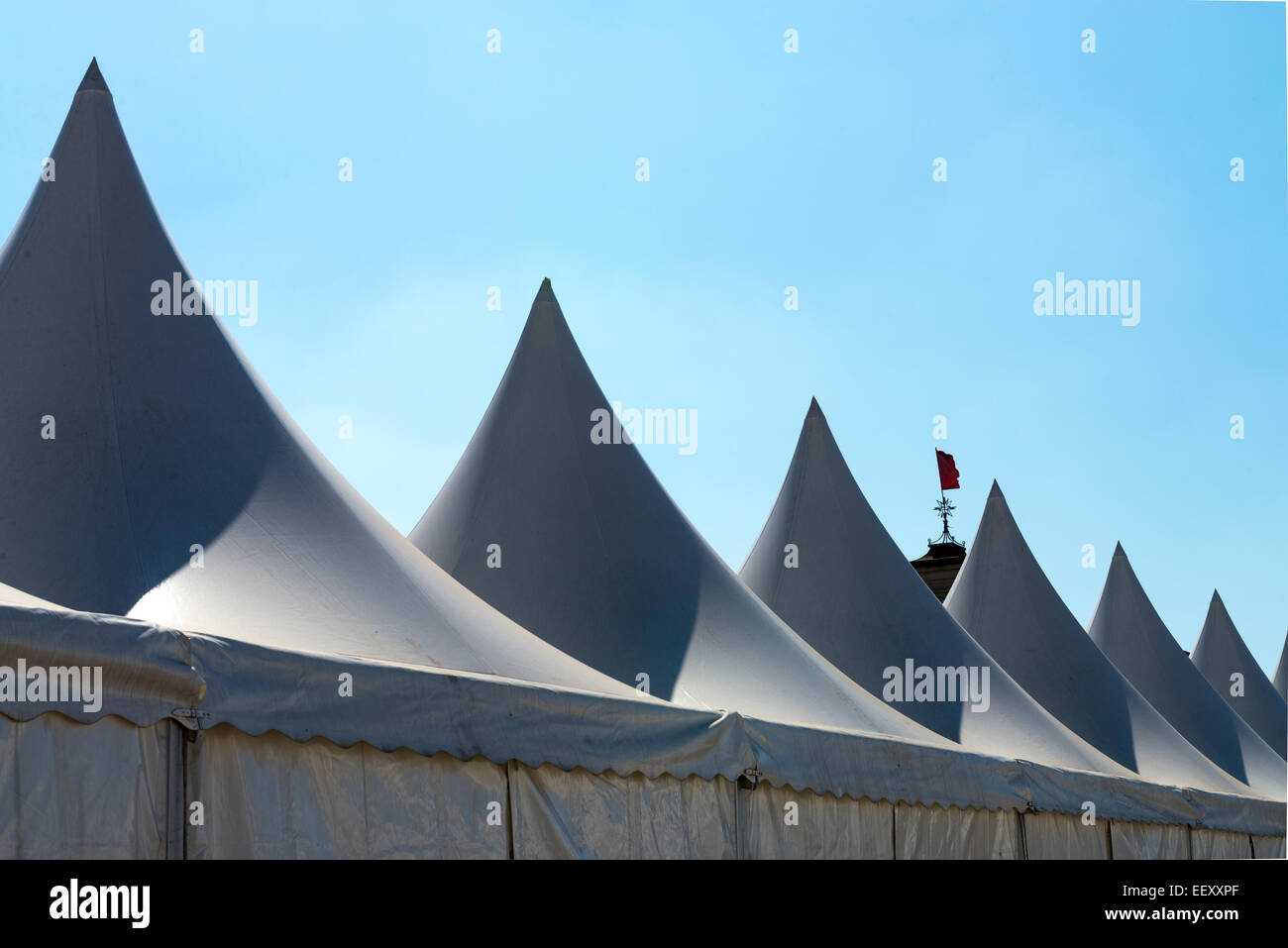 White tent for events with spier and blue sky Stock Photo