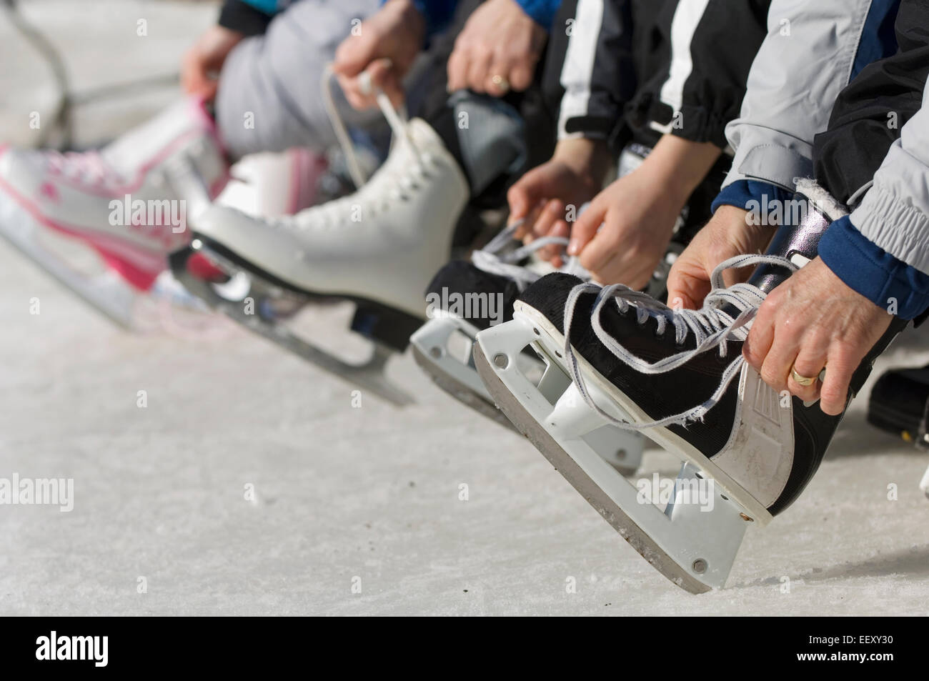 Family lacing up skates outdoors Stock Photo Alamy