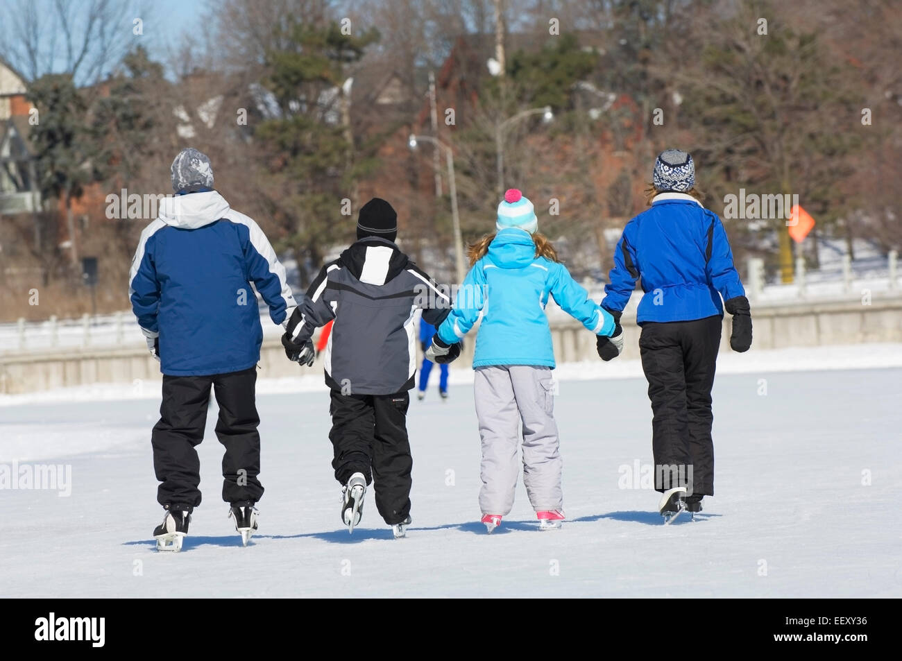 Family ice skating outdoors in winter together Stock Photo