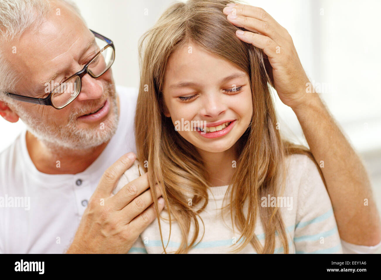 grandfather with crying granddaughter at home Stock Photo