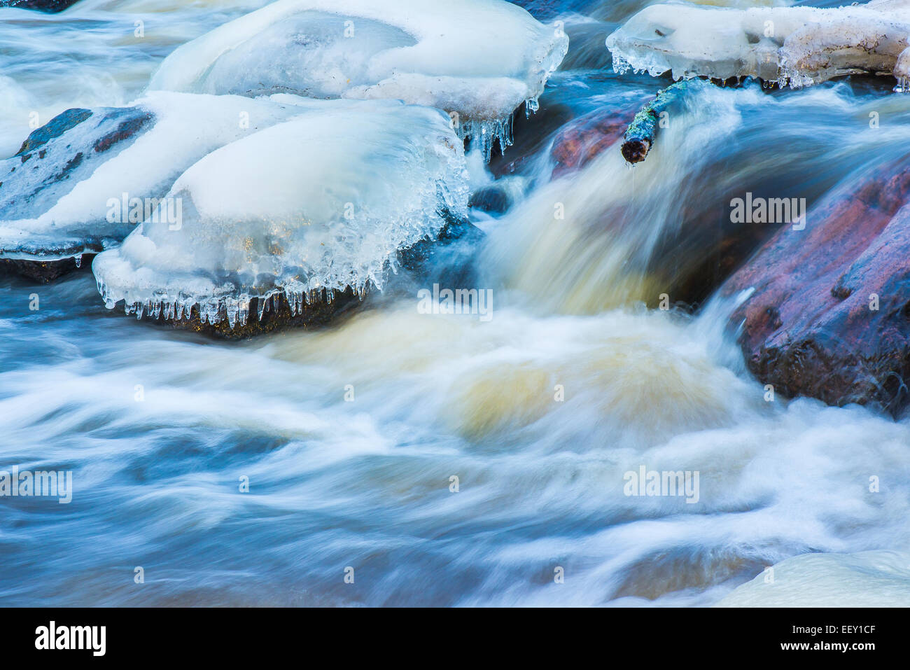 Long exposure shot in flowing winter stream Stock Photo