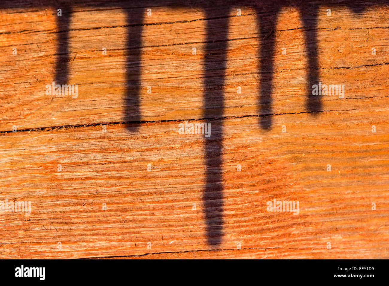 Shadow of icicles in red painted wood Stock Photo