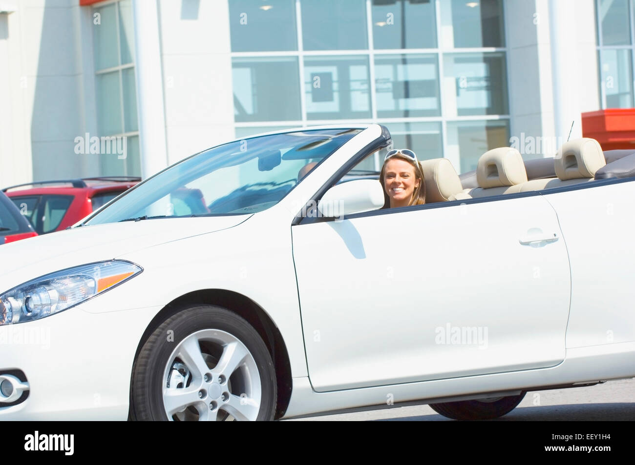 Couple leaving car dealership in convertible Stock Photo Alamy