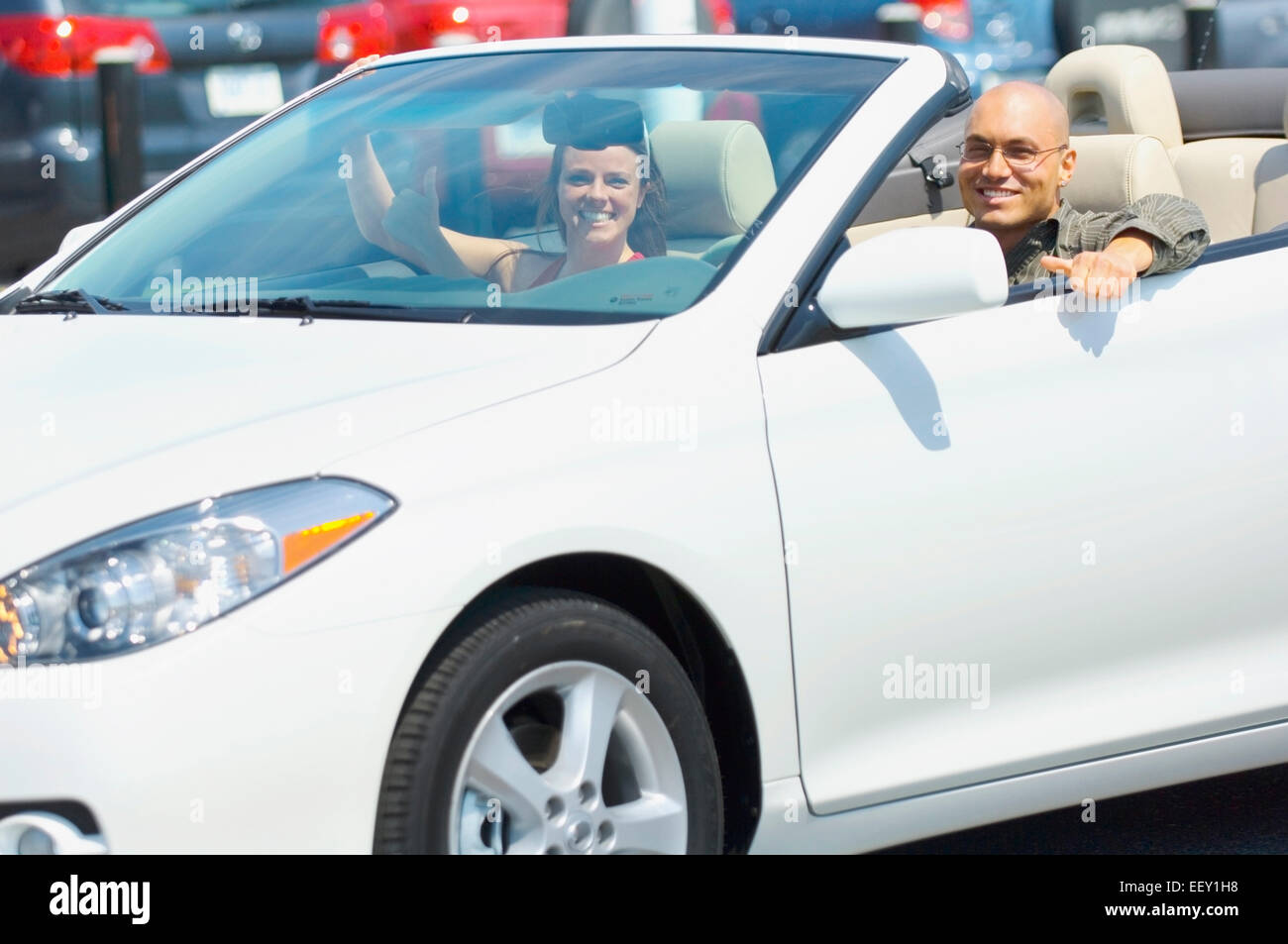 Couple leaving car dealership in convertible Stock Photo Alamy