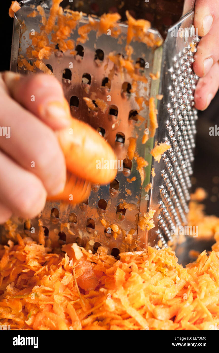 chef shredding carrots with grater in kitchen Stock Photo - Alamy