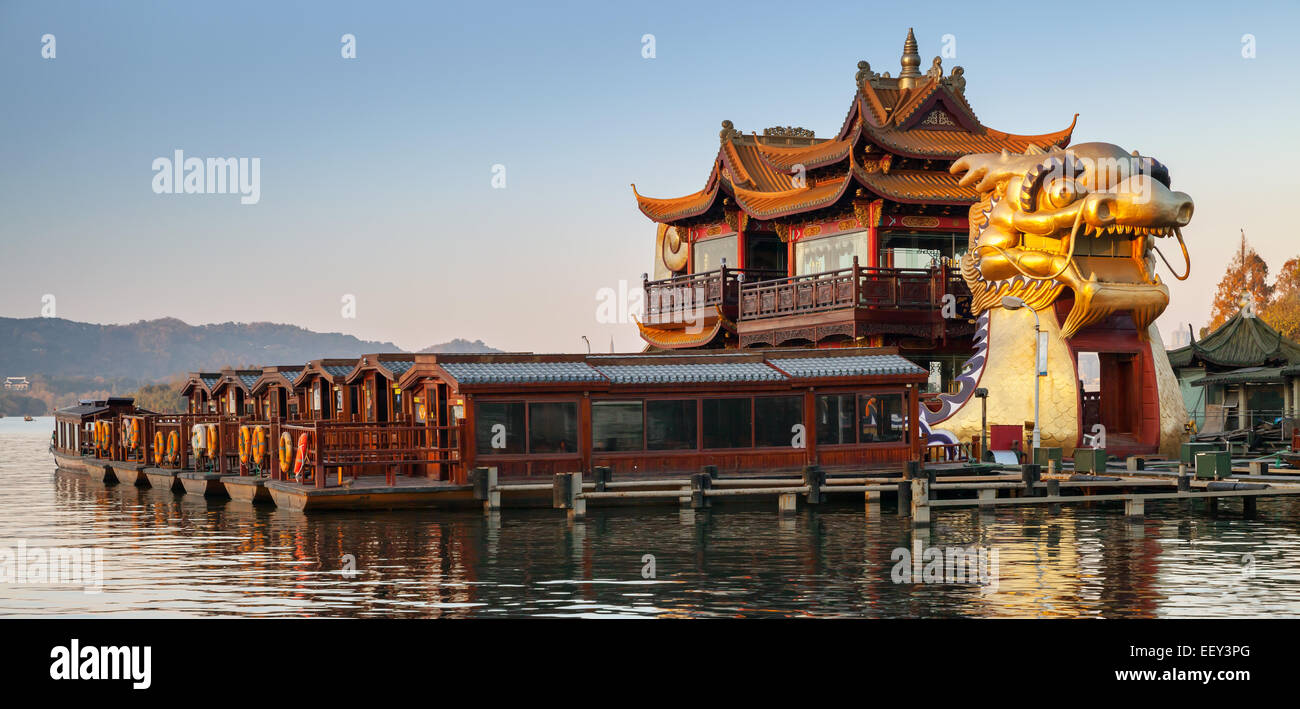 Hangzhou, China - December 5, 2014: Chinese wooden recreation boats and Dragon ship are moored on the West Lake. Famous park in Stock Photo