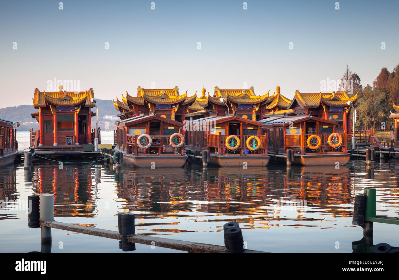 Traditional Chinese wooden recreation boats are moored on the West Lake coast. Famous park in Hangzhou city center, China Stock Photo