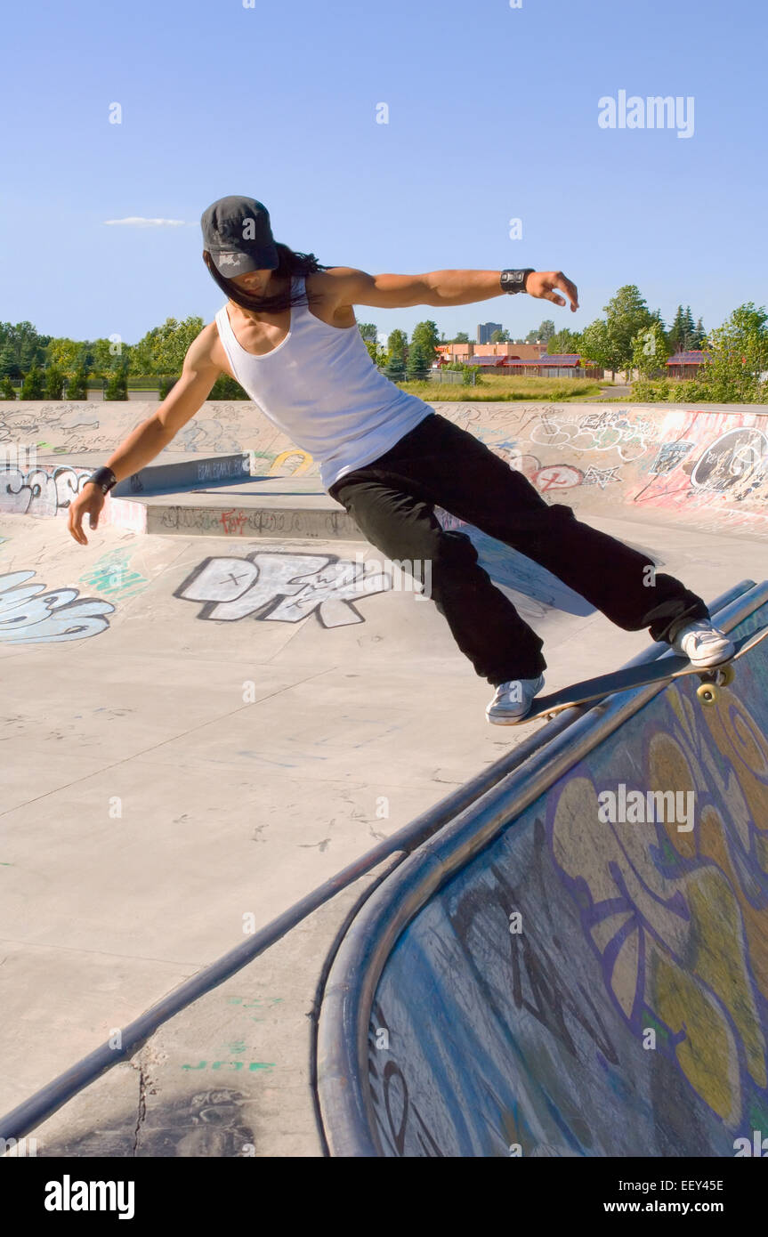Skateboarder sliding a rail at a skate park Stock Photo - Alamy