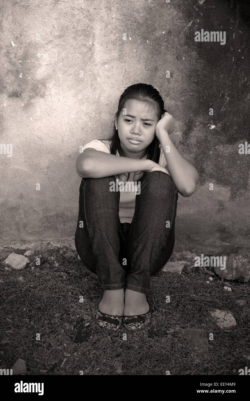 Young Asian lady crying in an abandoned place Stock Photo