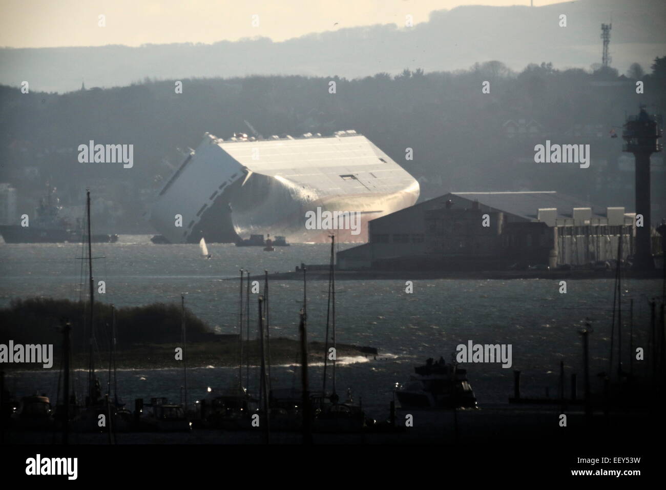 AJAXNETPHOTO. 6TH JANUARY, 2015. SOUTHAMPTON, ENGLAND. - CAR TRANSPORTER WRECK - THE GERMAN OWNED HOEGH OSAKA LISTING HEAVILY AFTER IT WAS DELIBERATELY RUN AGROUND ON THE BRAMBLE BANK AS IT WAS OUTBOUND FROM SOUTHAMPTON LATE ON 3RD JAN. SEEN LOOKING ACROSS THE SOLENT TOWARD CALSHOT FROM HAMBLE RIVER. PHOTO:STEVE FOULKES/AJAX REF:DSF150601 9580 Stock Photo