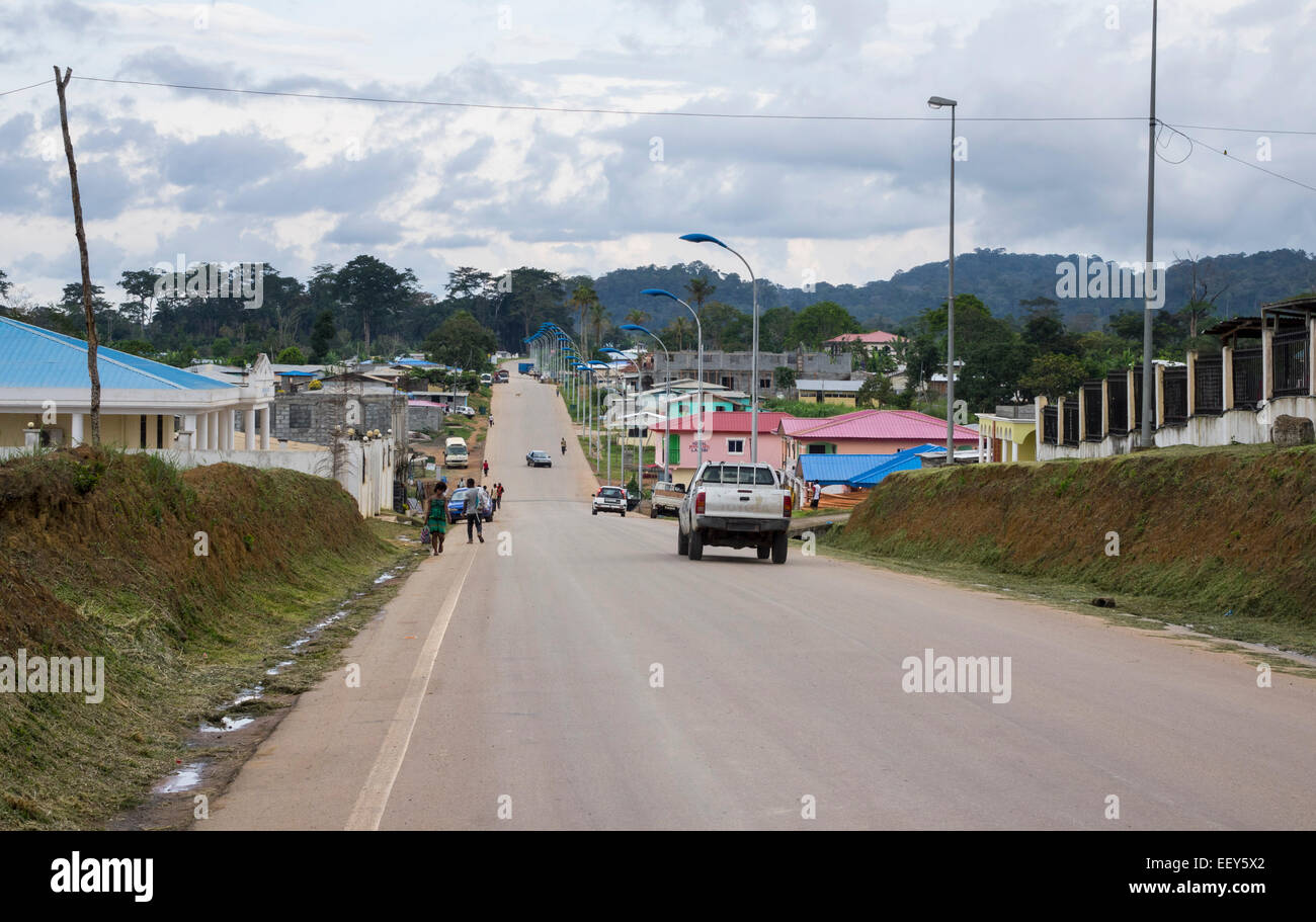 People and cars on the main street in town of Anisok in Equatorial Guinea, West Africa Stock Photo