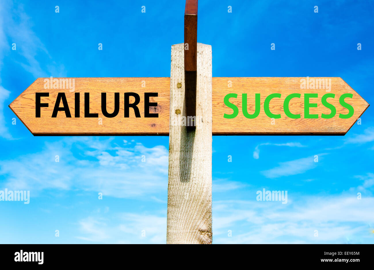 Wooden signpost with two opposite arrows over clear blue sky, Failure and Success messages, Success conceptual image Stock Photo
