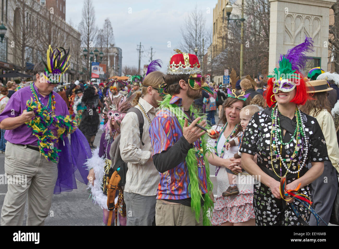 People wear costumes and colorful masks in the annual Mardi Gras parade
