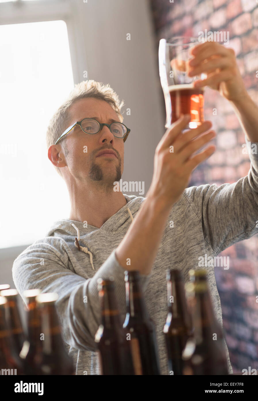 Man examining glass of beer Stock Photo