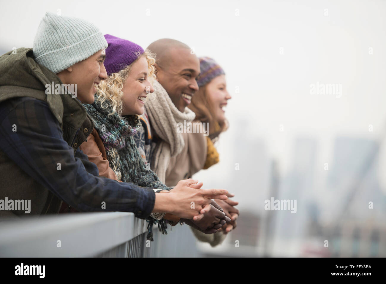 Friends standing on bridge and laughing Stock Photo