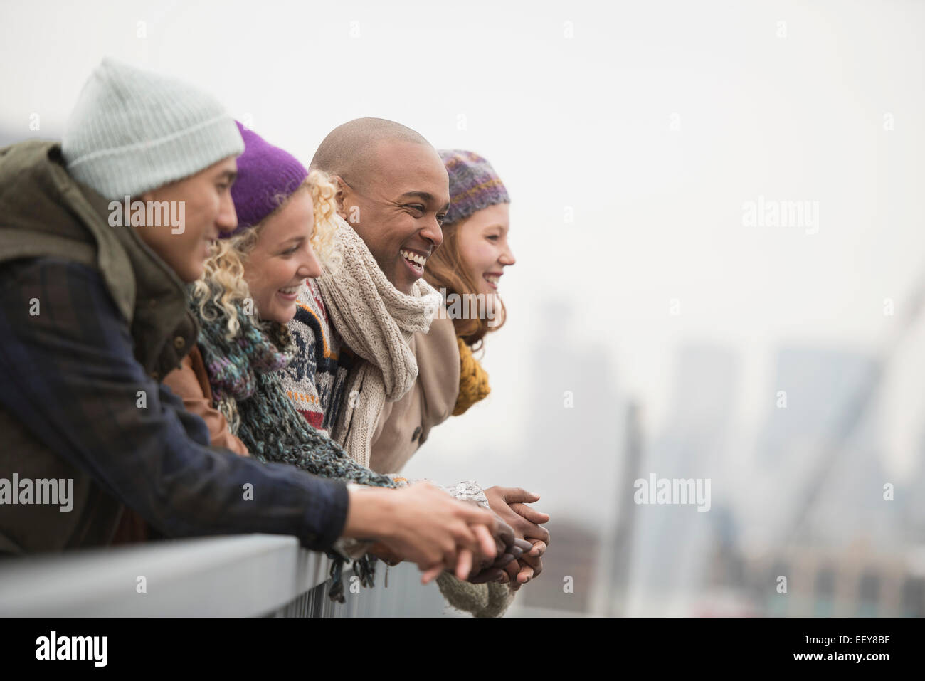 Friends standing on bridge and laughing Stock Photo