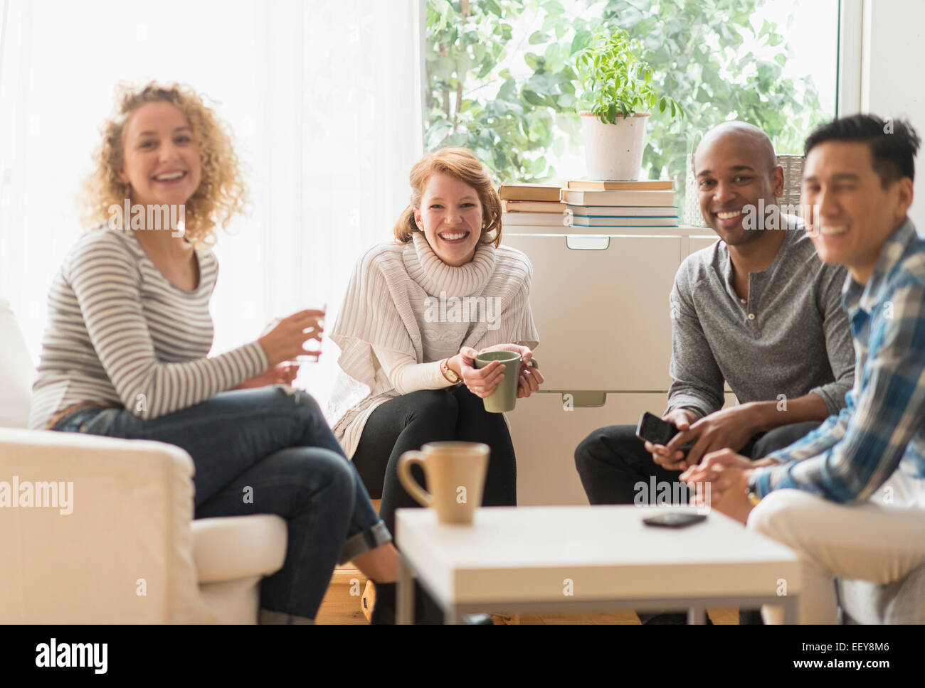 Group of friends hanging out in living room Stock Photo