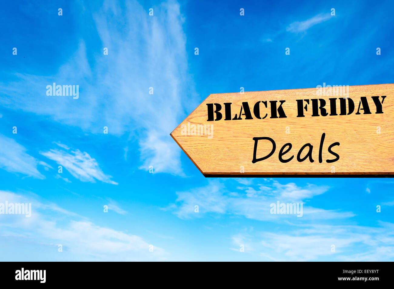 Wood arrow sign against clear blue sky with Black Friday Deals message, Sales conceptual image Stock Photo