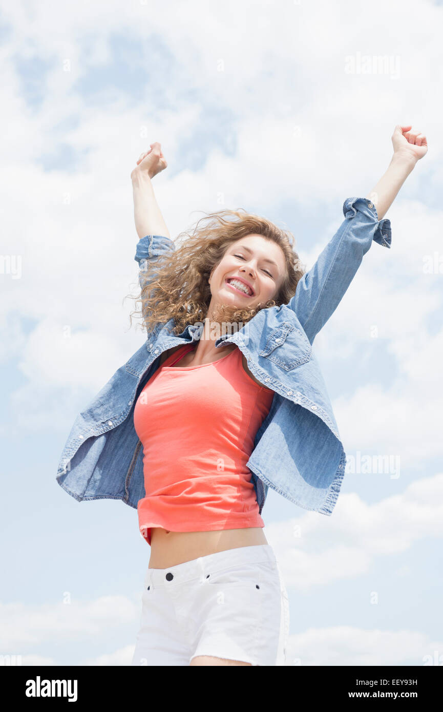 Portrait of young woman with arms raised Stock Photo Alamy