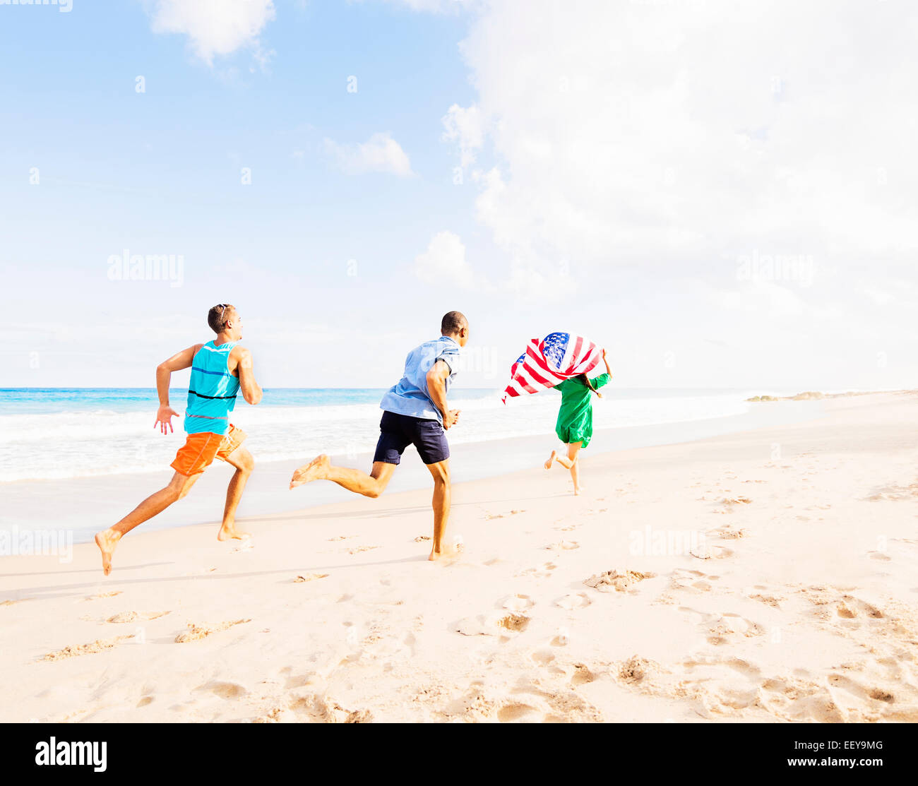 USA, Florida, Jupiter, Young people running with American flag on beach Stock Photo