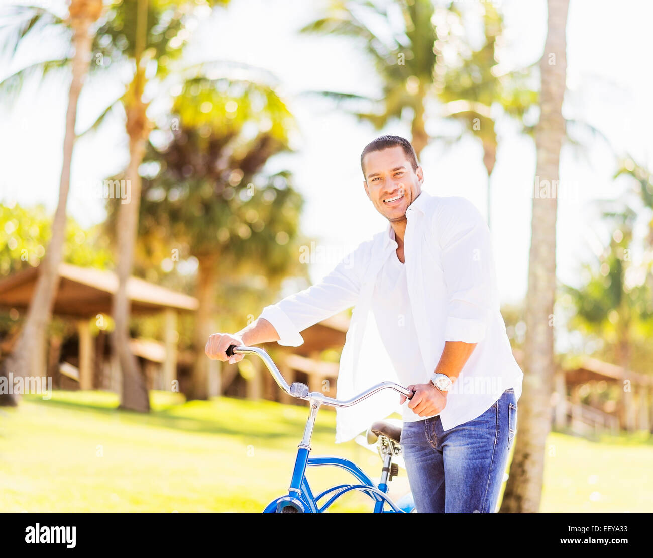USA, Florida, Jupiter, Man with bicycle with palm trees in background