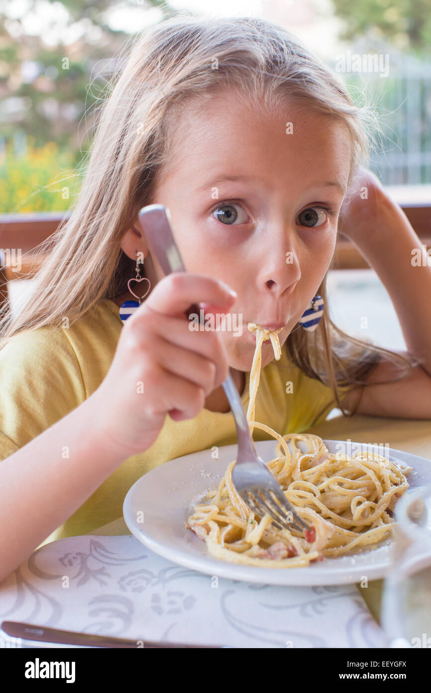 littlegirl eat Adorable little girl eating spaghetti in outdoors restaraunt Stock Photo -  Alamy