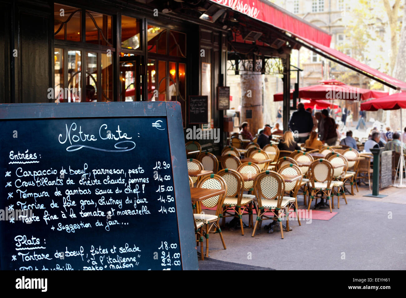 Typical cafe scene in Paris with tables and chairs arranged on the street. Stock Photo