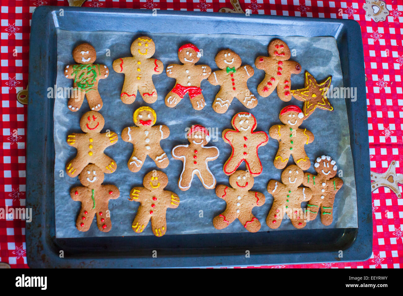Colorful gingerbread men on baking sheet for Christmas time Stock Photo