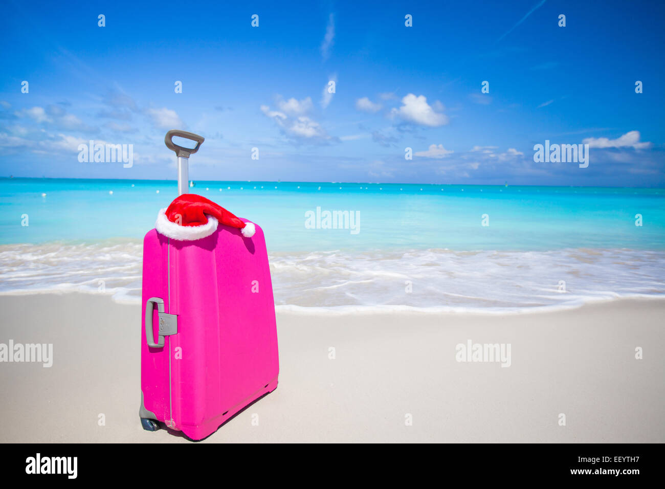 Closeup of pink suitcase and Santa Claus hat on beach Stock Photo - Alamy
