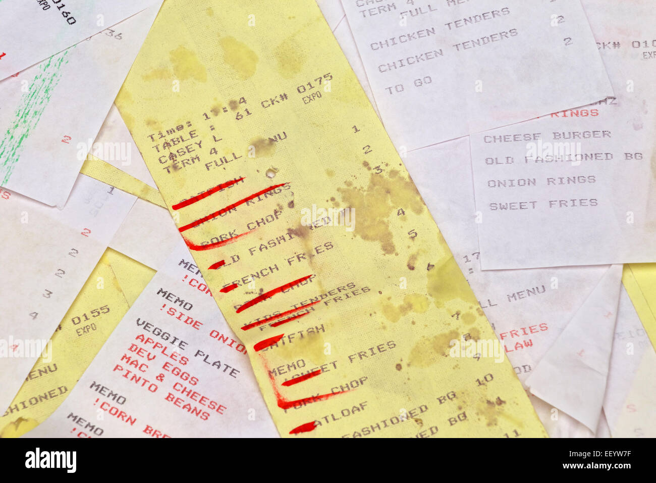 Yellow grease stained restaurant order ticket with items crossed off. Stock Photo